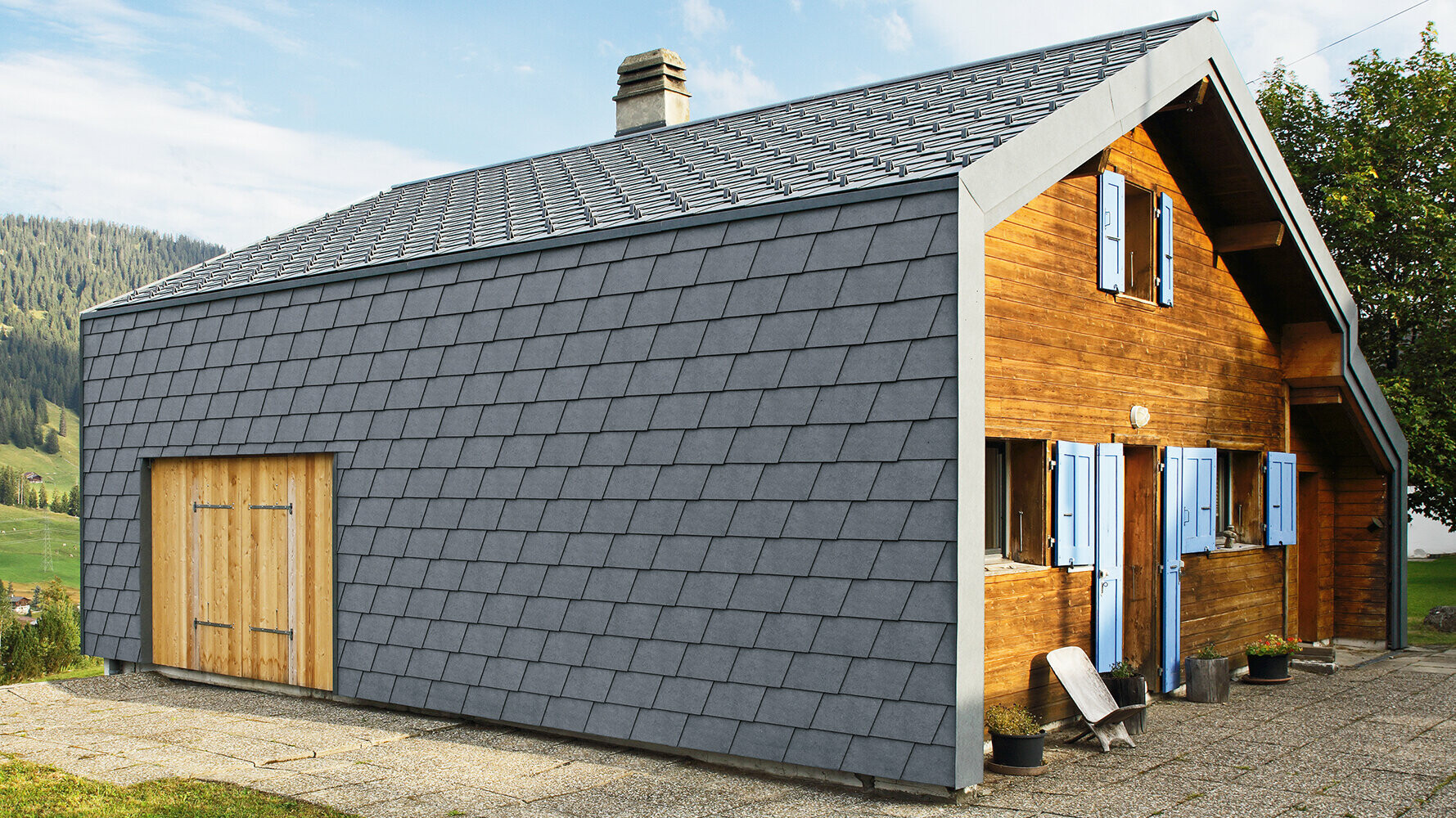 Moderna casa monofamiliare rivestita con scandole per facciata PREFA color antracite ed elementi in legno.