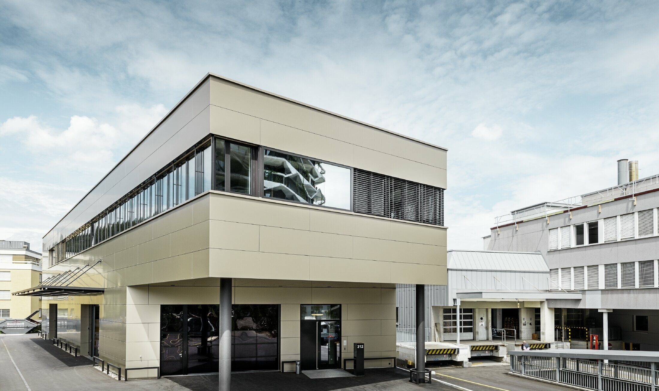 Moderner Zubau mit Werkstatt und Büro von Guggisberg Dachtechnik mit der PREFA Aluminium Verbundplatte in bronze