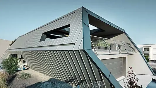sehr modernes Einfamilienhaus mit außergewöhnlicher Architektur, mit einer Winkelstehfalzfassade aus Aluminium von PREFA in hellgrau