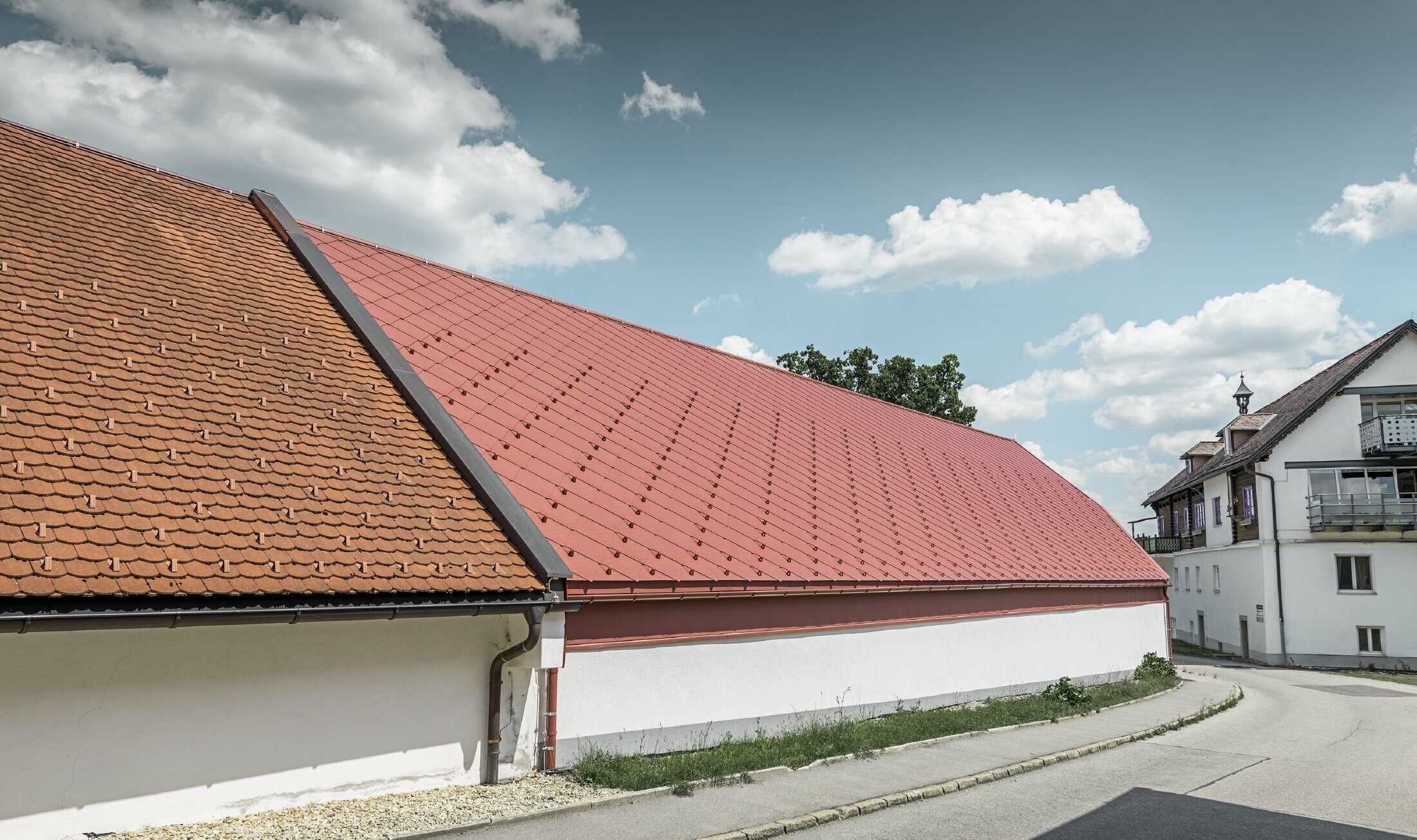Foto esterna del Kerzenwelt a Schlägl; il tetto è stato rivestito con la scaglia in alluminio PREFA 44x44 in rosso ossido.