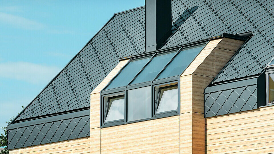 Einfamilienhaus mit Satteldach ohne Dachvorsprung mit einer Fassade in Holzoptik und einem Aluminiumdach in anthrazit
