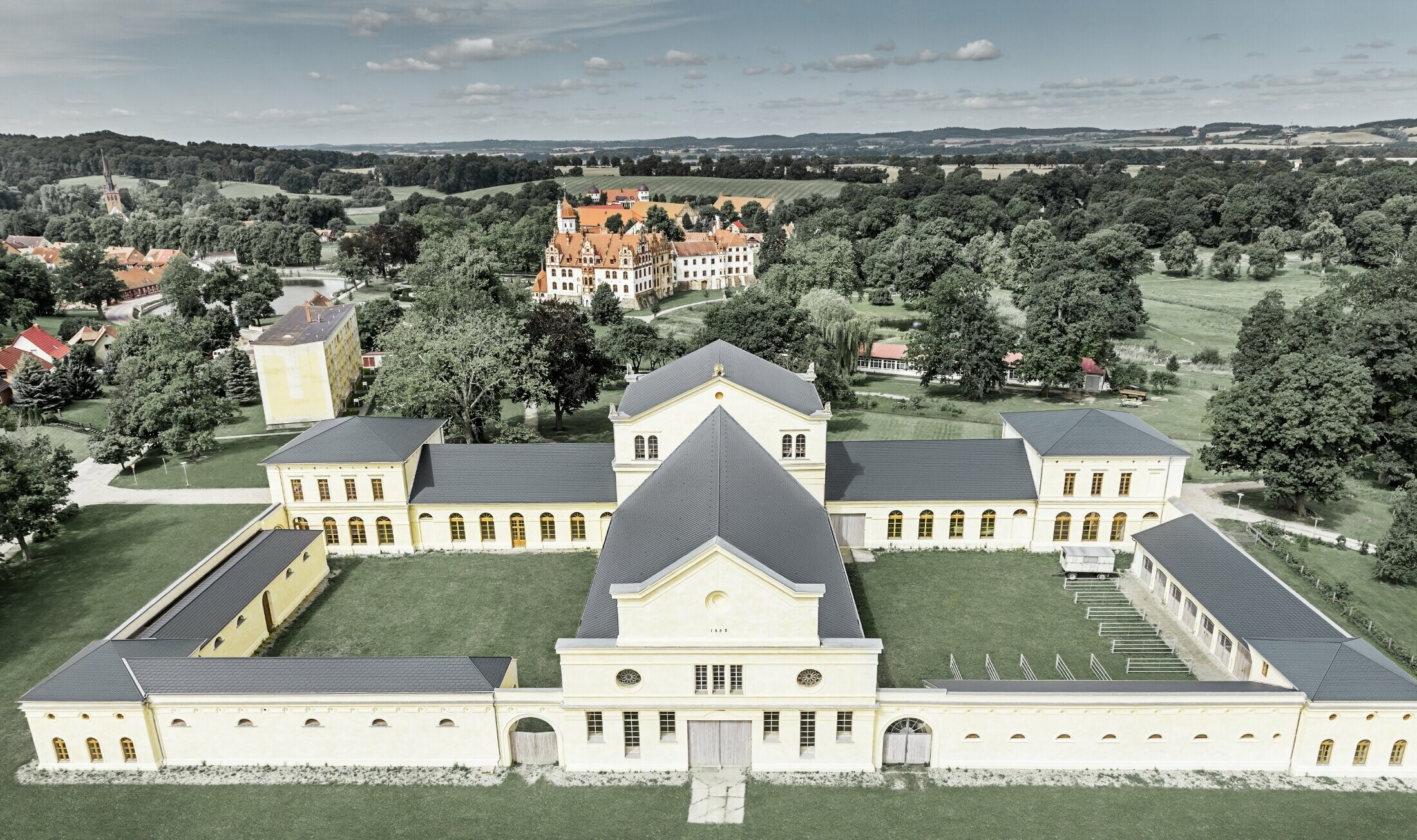 Aufnahme in der Vogelperspektive des Marstalls in Basedow; Das neu renovierte Schloss im Renaissancestil hat auch ein neues Dach mit der PREFA Dachschindel in Anthrazit.