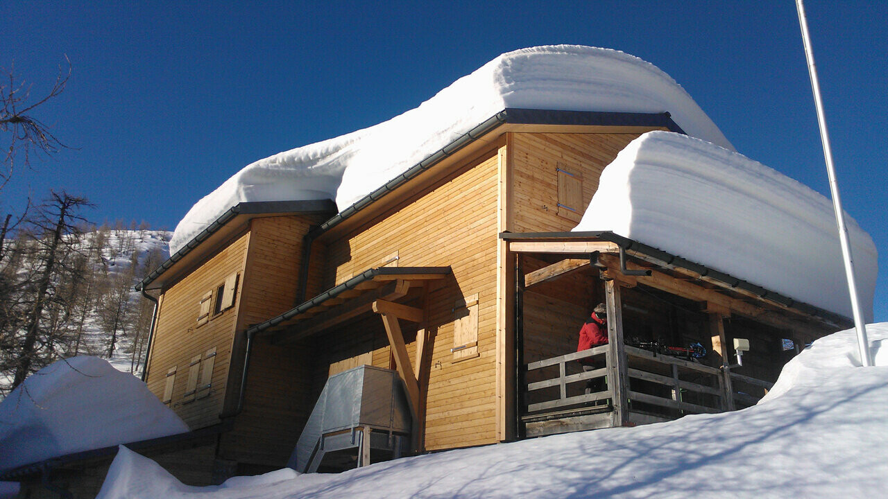 La baita Capanna Buffalora con diversi centimetri di neve sul tetto. 