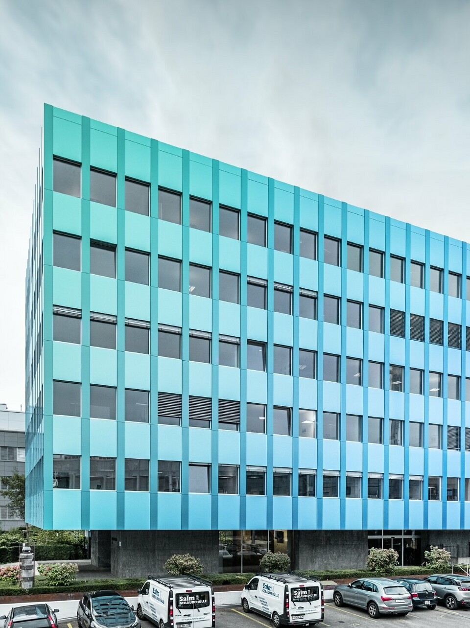 seitliche Ansicht des Wielandhauses in Aarau; Die Fassade ist mit der PREFABOND Verbundplatte aus Aluminium von PREFA verkleidet, die durch das besondere Beschichtungsverfahren in Blau-grün schimmert