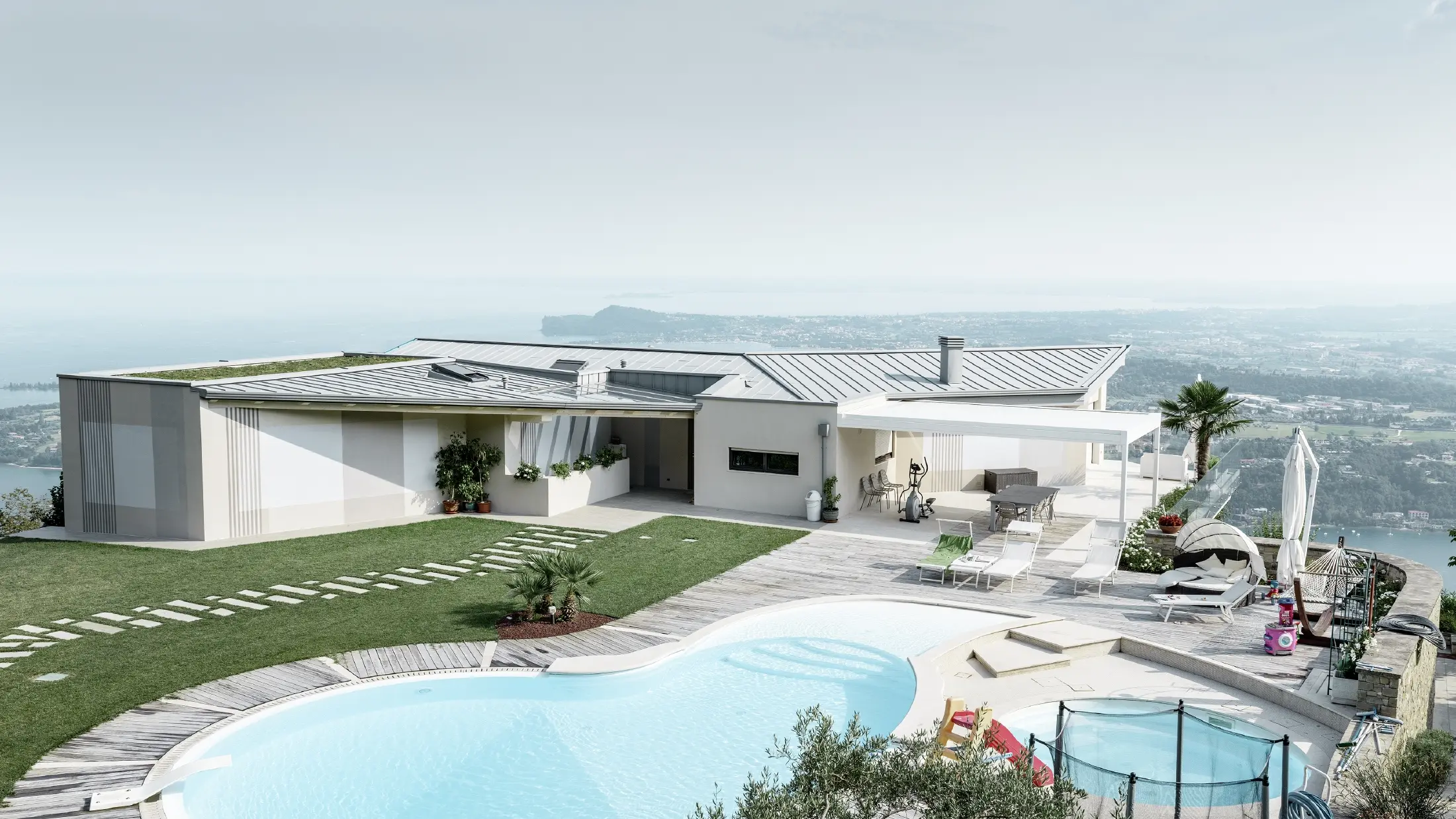 Tenuta su una collina con ampia vista del paesaggio, grande terrazzo e piscina con copertura aggraffata in patina grigio