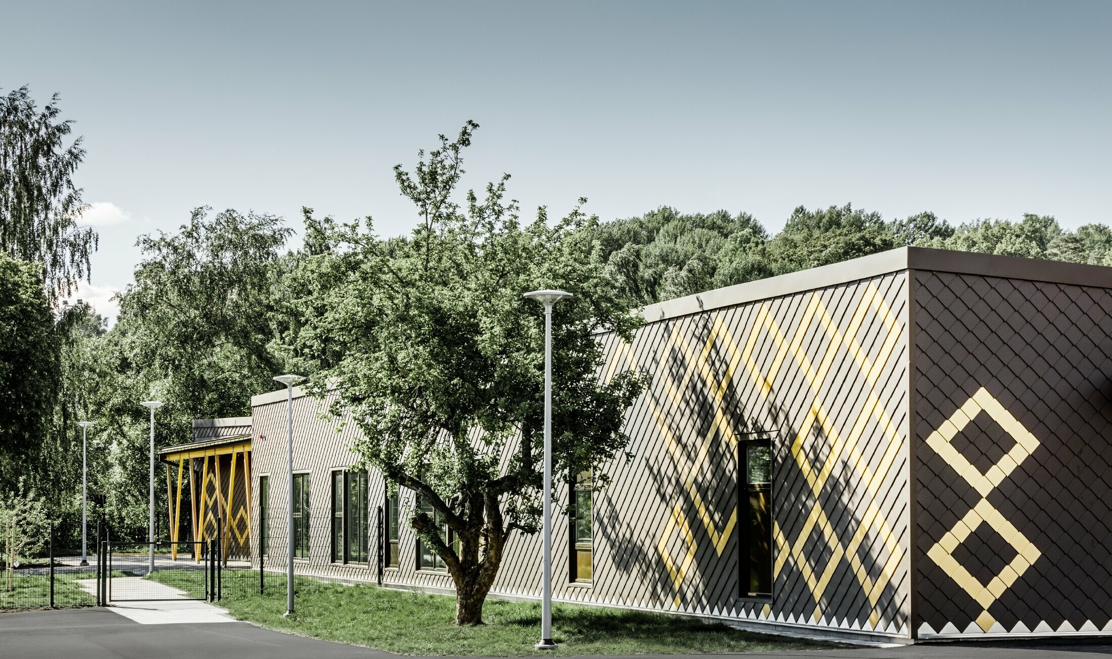 La scuola materna di Stoccolma è stata rivestita con la resistente facciata in alluminio di PREFA. Le losanghe in marrone e mayagold creano un interessante motivo.