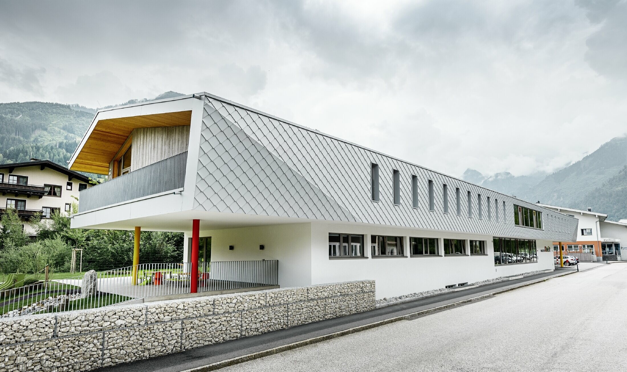 Nuova costruzione della scuola d'infanzia a Kaprun con una facciata moderna con la scaglia PREFA in bianco prefa