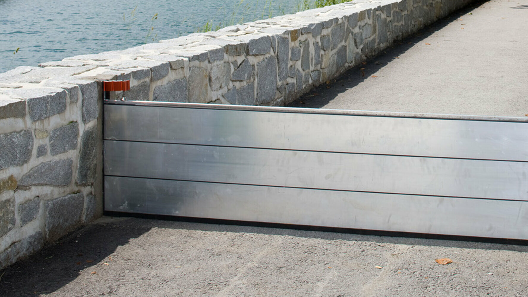 Marciapiede nelle vicinanze di un fiume con sistema anti-esondazione PREFA