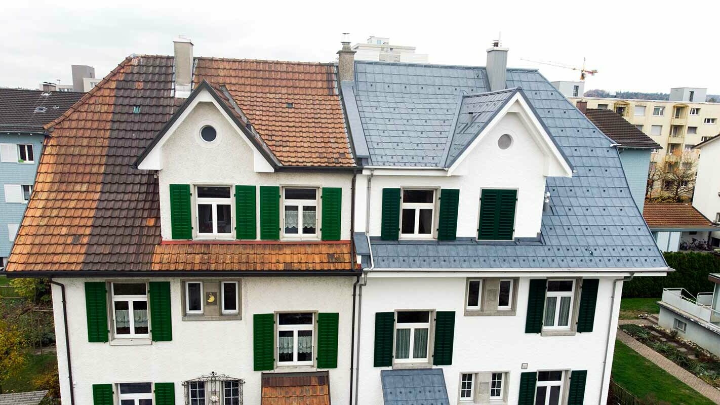 Doppelhaushälfte in der Schweiz; Der linke Gebäudeteil wurde noch nicht saniert und ist noch mit fleckigen Dachziegeln eingedeckt. Der rechte Gebäudeteil wurde mit den PREFA Dachplatten in Steingrau eingedeckt.