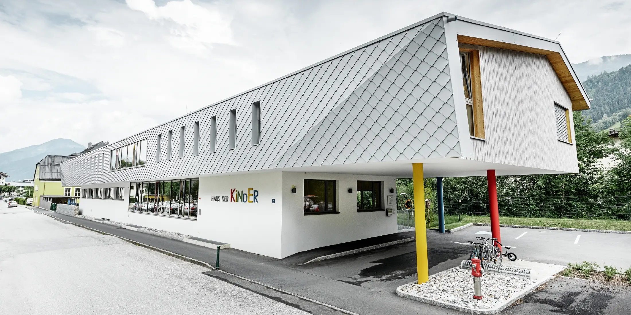 neu gebauter Kindergarten in Kaprun mit einer modernen Aluminium Fassade mit der PREFA Wandraute in prefaweiss