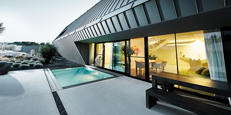 Modernes Gebäude mit Terrasse und Pool, eingedeckt mit Prefalz Aluminium Elementen von PREFA