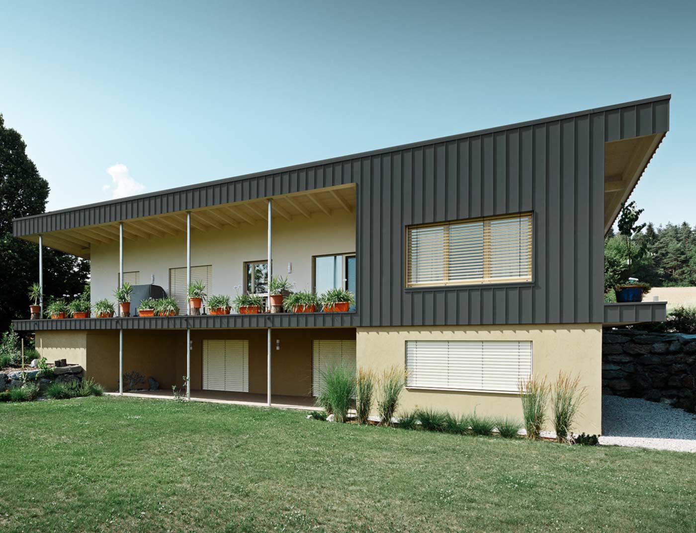 Modernes Einfamilienhaus mit einer Winkelstehfalzfassade von PREFA, verkleidet mit Prefalz in Dunkelgrau;