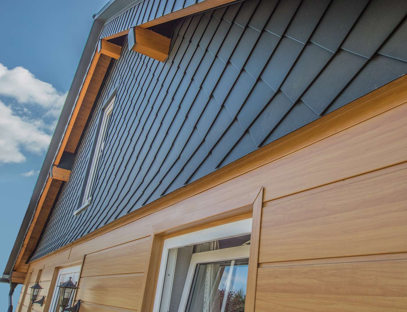 PREFA Wandgestaltung mit den Sidings in Holz hell, sowie einer Giebelverkleidung in Anthrazit mit den PREFA Wandrauten 20 × 20.